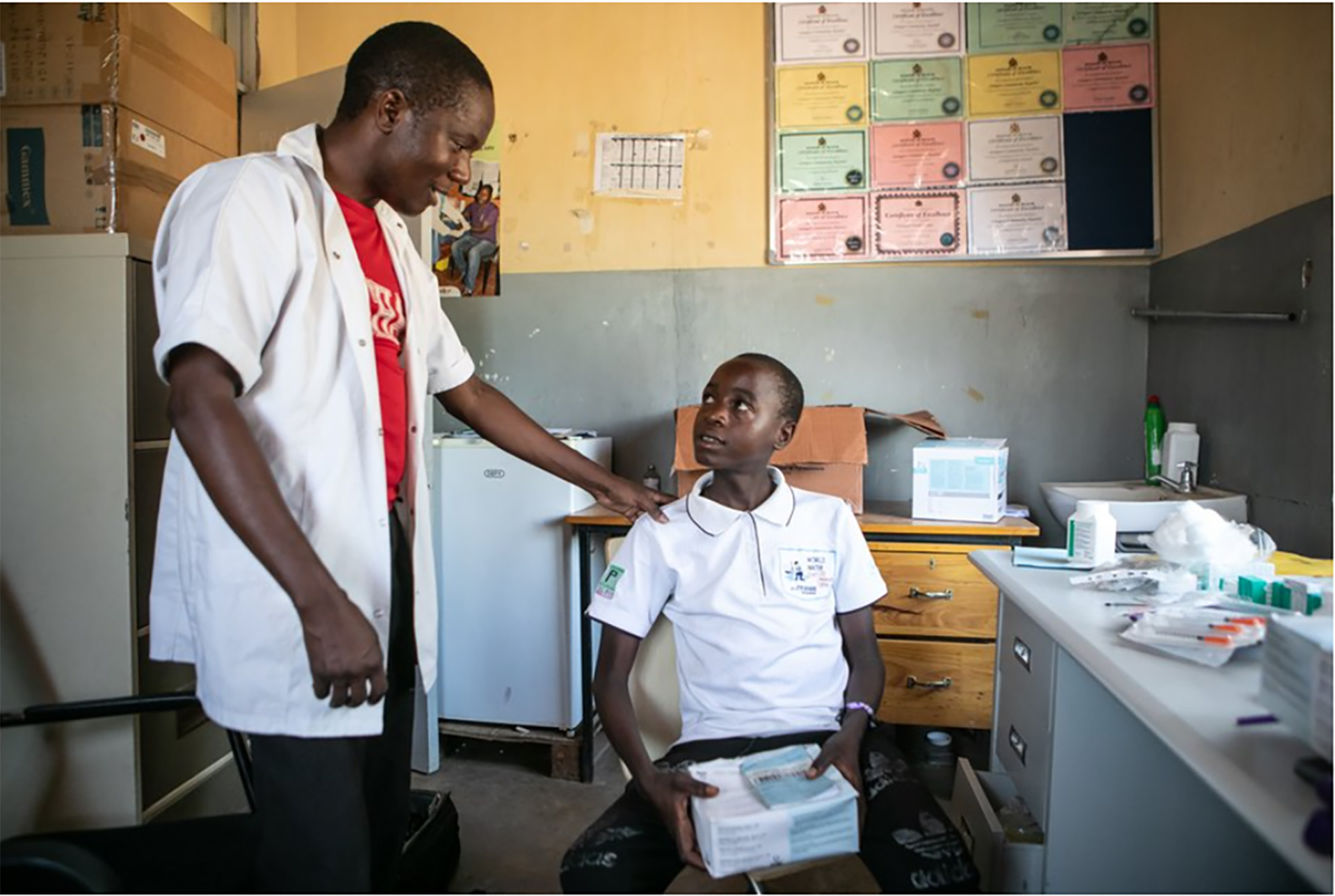 a health worker talking to a child in a clinic