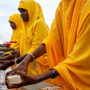 A group of African women washing their hands with soap and water